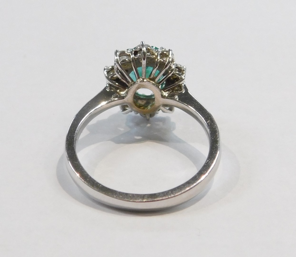 An 18ct white gold emerald and diamond ring, the oval cut emerald in a surround of brilliant cut dia - Image 3 of 4