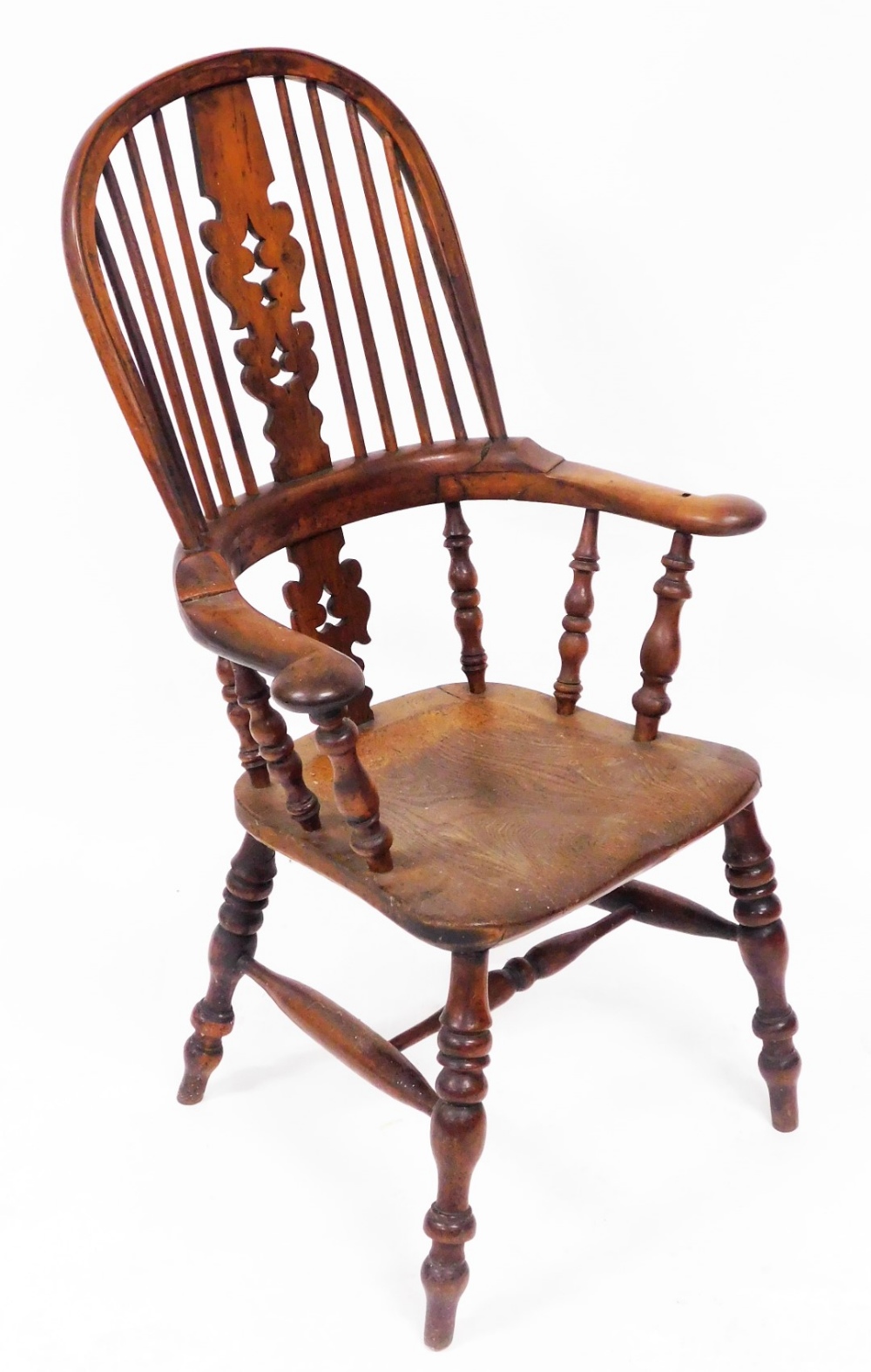 A Victorian yew and elm Windsor chair, with a carved splat, scrolling arms, solid saddle seat, raise