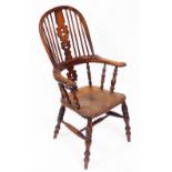 A Victorian yew and elm Windsor chair, with a carved splat, scrolling arms, solid saddle seat, raise