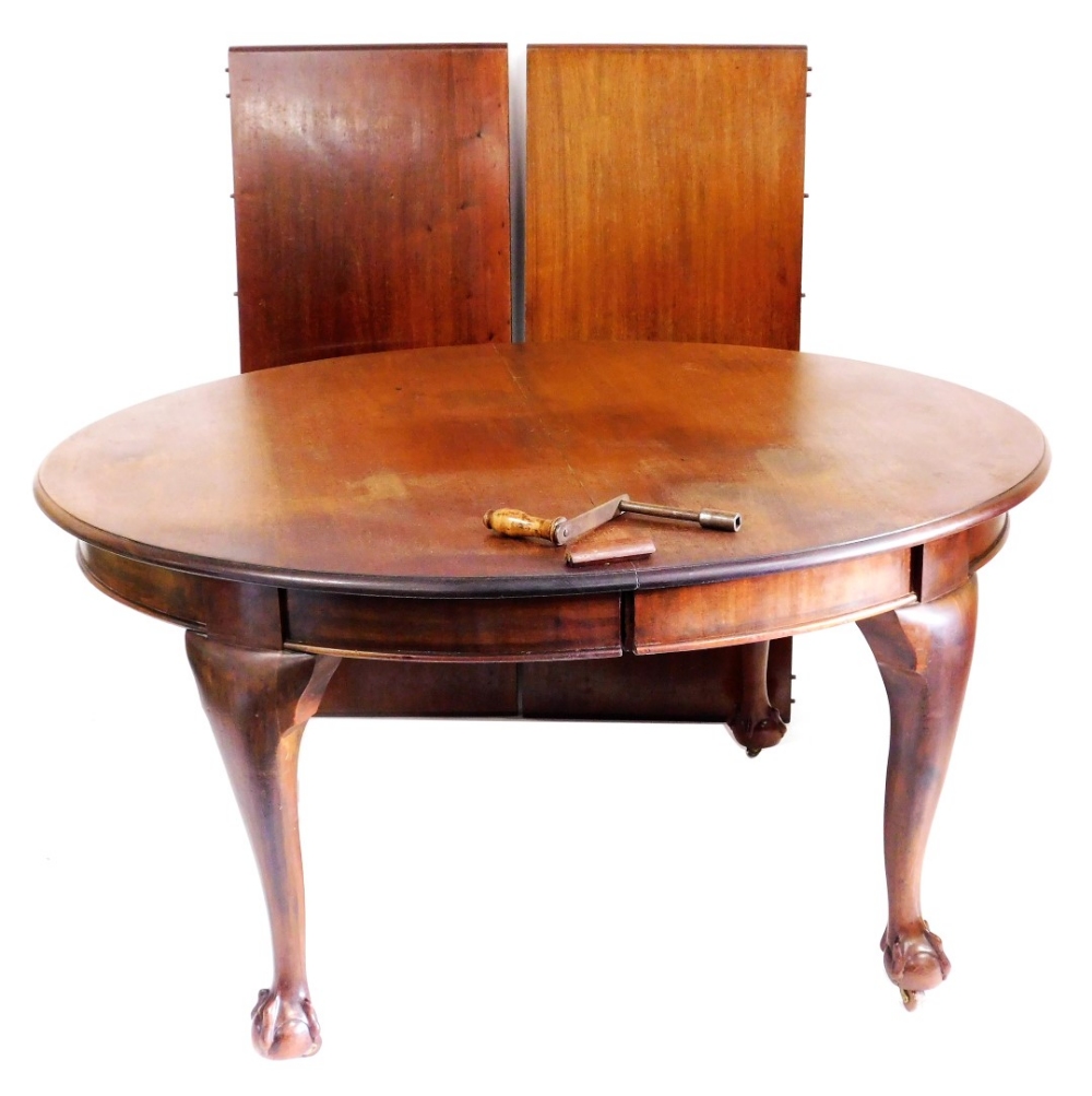 A Victorian mahogany extending dining table, the oval moulded top raised on four ball and claw feet,