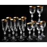 A set of six Bohemian cut glass champagne flutes, each with a gold coloured rim, and gilt highlight