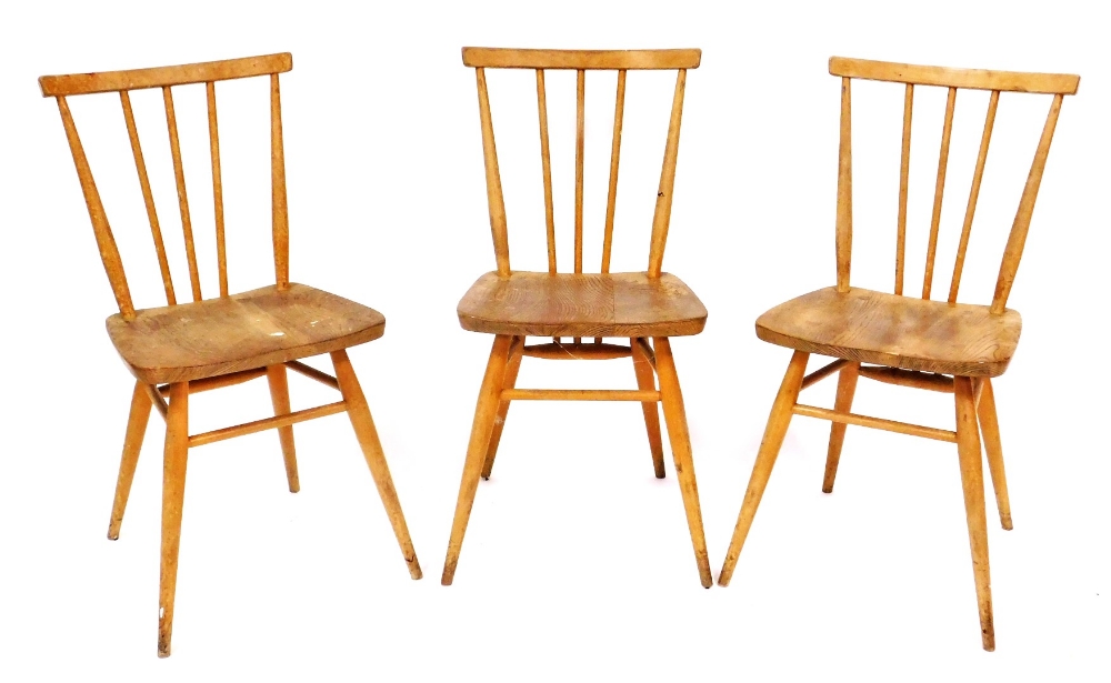 A set of three Ercol ash and elm stick back chairs, each with a solid seat on turned legs with stret
