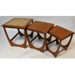 A nest of three mid 20thC teak tables, the largest with a tiled top, each raised on U shaped solid s