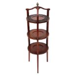 An Edwardian mahogany three tier cake stand, the upper circular platform with carved border, and wit