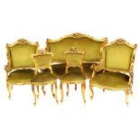 A late 19thC Continental parcel gilt salon suite, each carved with a cherub's head and floral crest