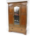 An Edwardian mahogany and inlaid double wardrobe, the outswept pediment over a single door, inset be