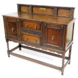 An early 20thC oak dresser, the top with a raised carved back, above a moulded edge, the base with t