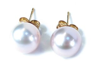 A pair of 9ct gold cultured pearl studs, each on a single pin back with butterfly back in a pinkish