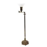 A brass adjustable lamp, with white opaque holophane type shade, reeded column and domed base, 146cm