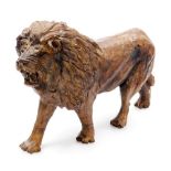 A carved wooden figure of a lion, signed D. Mudede, in standing pose, 22cm wide.