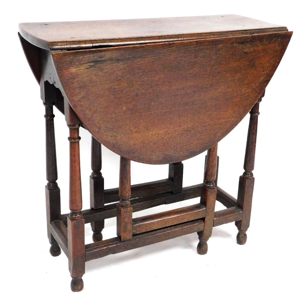 An 18thC oak drop leaf occasional table, with a single frieze drawer, raised on turned legs united b