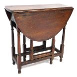 An 18thC oak drop leaf occasional table, with a single frieze drawer, raised on turned legs united b