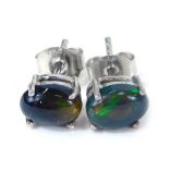 A pair of Ethiopian cabochon black opal stud earrings, each in a basket four claw setting, on single