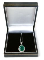 An 18ct gold emerald and diamond cluster pendant, with oval emerald, totalling approx 3.55ct, in a f