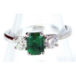 An 18ct white gold and emerald and diamond three stone dress ring, with central rectangular cut emer