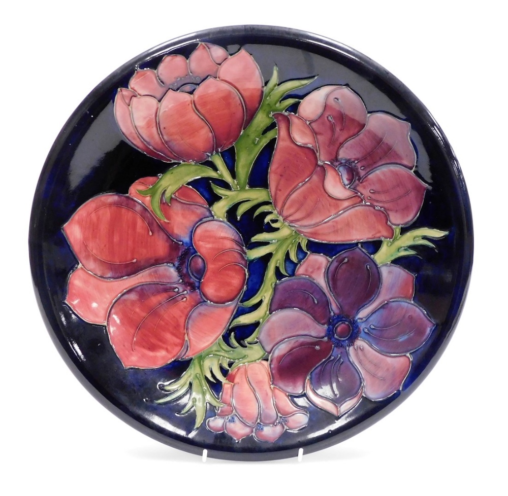 A Moorcroft Anemone pattern pottery charger, blue ground, impressed and painted marks, 35cm diameter