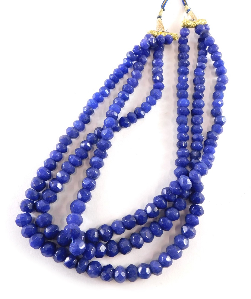 A reconstituted sapphire beaded necklace, of graduated form with three strands on a adjustable slip