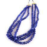 A reconstituted sapphire beaded necklace, of graduated form with three strands on a adjustable slip