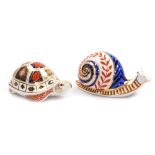Two Royal Crown Derby porcelain paperweights, seconds, comprising Snail, red printed marks and silve