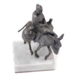 A Continental white metal sculpture, cast as a pheasant woman atop a donkey, with flasks at her side
