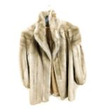 A lady's Astraka fur three quarter length coat, underarm measurement 40cm.