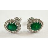 A pair of 18ct white gold emerald and diamond cluster stud earrings, each with central emerald both