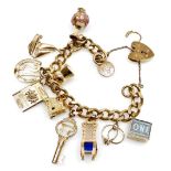 A 9ct gold curb link charm bracelet, with eleven charms as fitted, on a heart shaped padlock clasp,