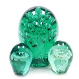 A 19thC green glass dump, with a bubbled interior, 12cm high, together with two further dumps, each