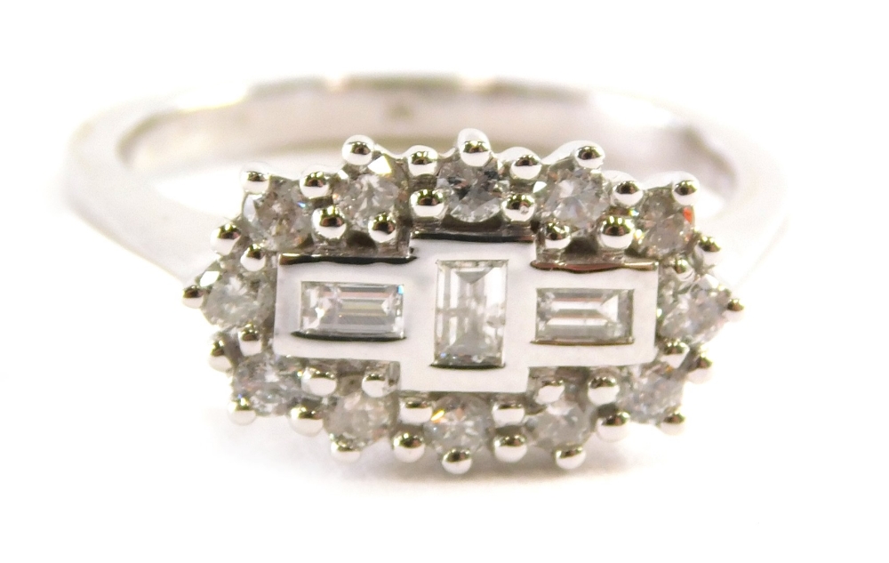 An 18ct white gold boat style diamond dress ring, set with an arrangement of three baguette cut sto
