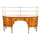 A George III flame mahogany break front sideboard, with brass curtain rail to the top and curved cro