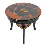 An early 20thC Japanese lacquer coffee or occasional table, the circular top decorated with figures,