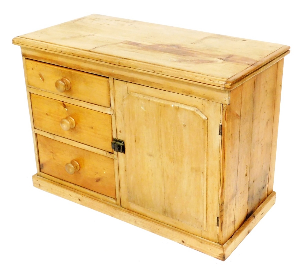 A Victorian pine dresser, with three graduated drawers having turned knop handles and a cupboard wit