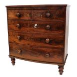 A Victorian mahogany bow front chest, of two short over three long graduated drawers, raised on turn