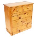 A Victorian pine chest of drawers, the top with a rounded edge, above two short and three long drawe