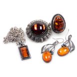 A group of amber jewellery, set in white metal, comprising a ring, pair of leaf and berry drop earri