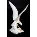 A German white glazed porcelain figure of a gull, possibly Max Esser for Meissen, perched on a wave,
