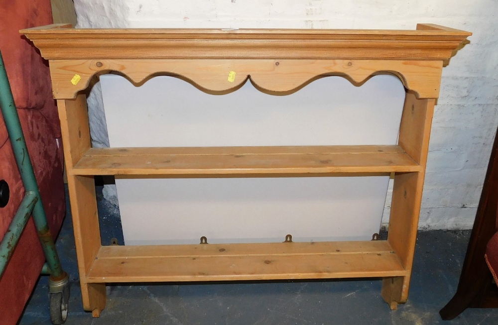 A pine hanging wall shelf, the top with a moulded cornice above a carved apron, with two shelves, 90