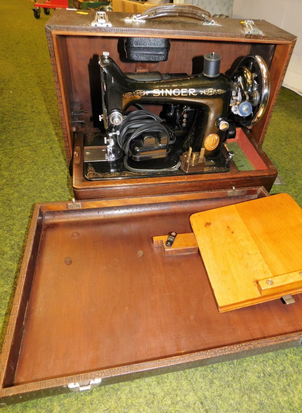 A cased Singer sewing machine. Buyer Note: WARNING! This lot contains untested or unsafe electrical