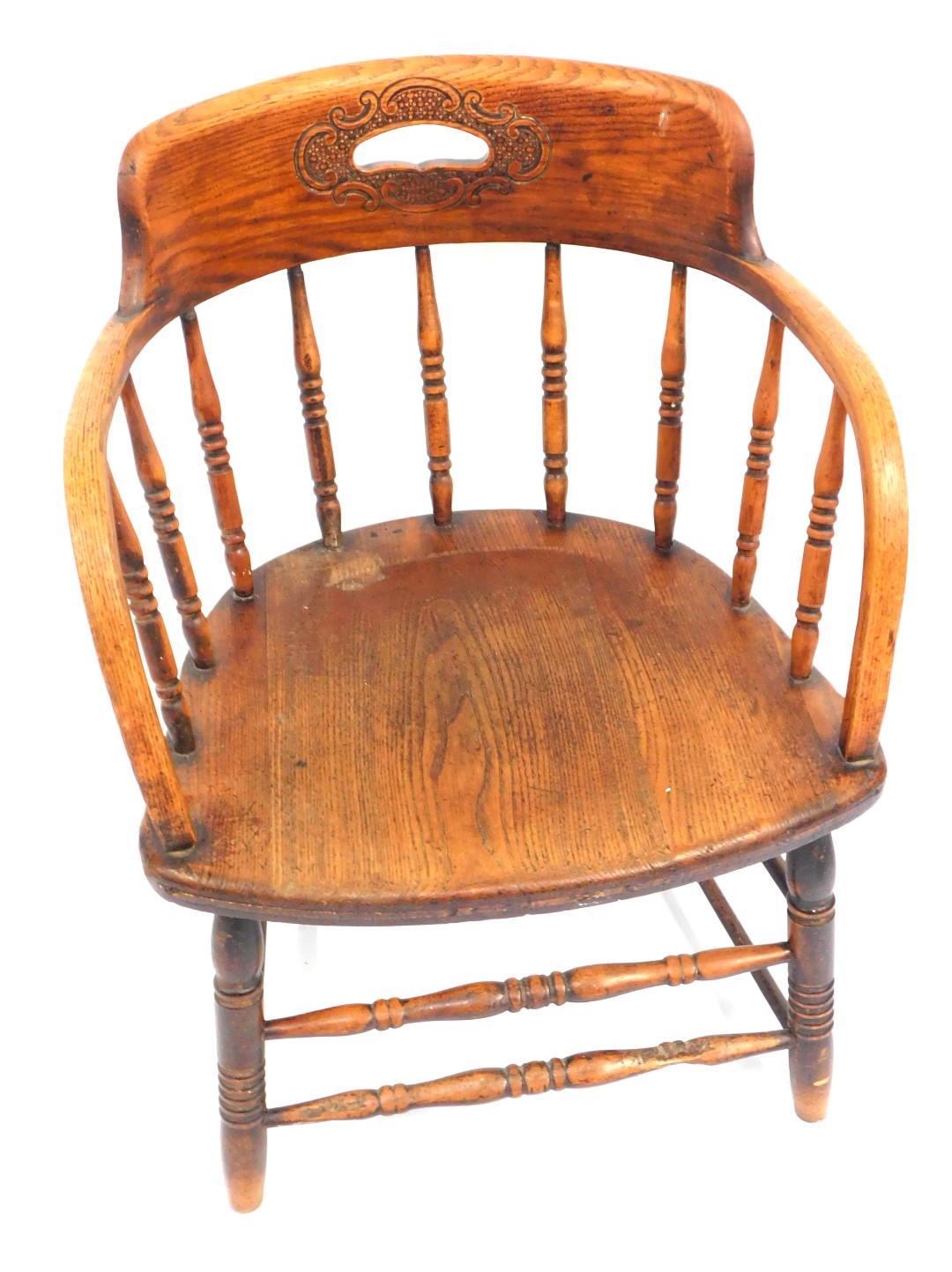 An early 20thC oak Captain's chair, with a carved floral back and shaped supports, on twin banded le