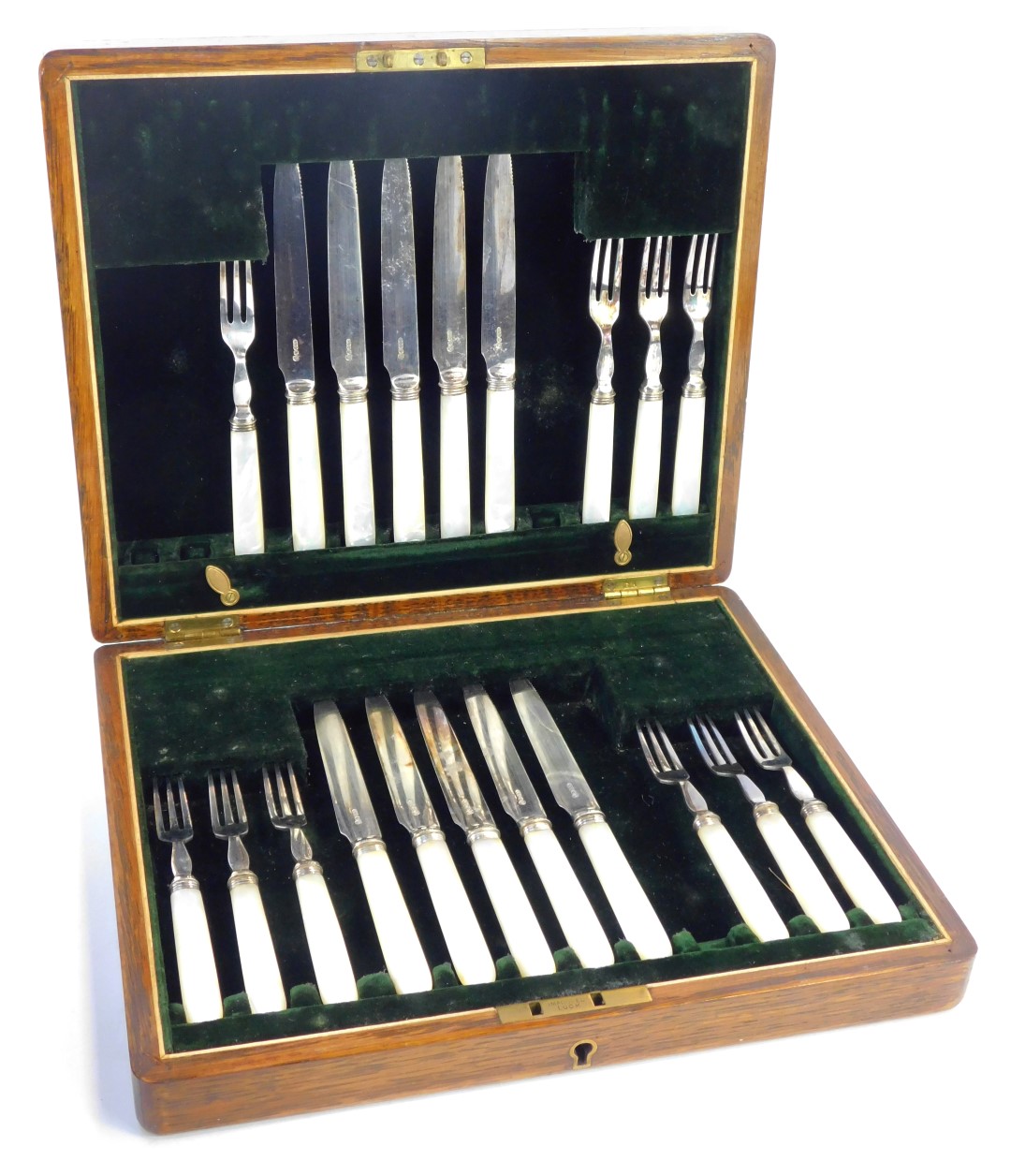 A part canteen of mother of pearl and stainless steel bladed fruit knives and forks, in a fitted oak