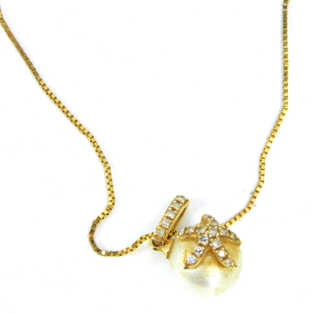 A cultured pearl pendant, set with a starfish, with tiny diamond set link, yellow metal stamped 14k,