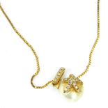 A cultured pearl pendant, set with a starfish, with tiny diamond set link, yellow metal stamped 14k,