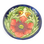 A Moorcroft Pottery dish decorated with flowers, painted and impressed marks, 11.5cm wide, boxed.