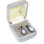 A pair of Moonstone and black enamel drop earrings, each formed as a tear drop, yellow metal backs,