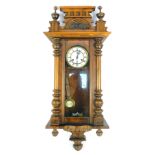 A late 19thC walnut cased Vienna wall clock, with a moulded top, Corinthian columns with white ceram