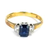 An 18ct gold sapphire and diamond dress ring, with a rectangular cut central sapphire, in a raised f