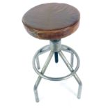 A mid century industrial tubular steel laboratory stool, with an adjustable circular tan leather sea