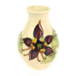 A Moorcroft Pottery vase decorated in the Columbine pattern, impressed and painted marks, 14cm high.