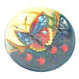 A Moorcroft Pottery dish decorated with a butterfly and berries, circa 2002, painted and impressed m