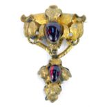 A Victorian gilt metal brooch, comprising one of heavy scroll decoration with cabachon red paste sto